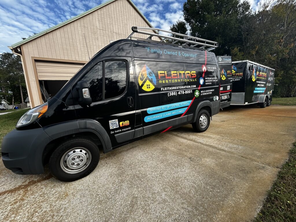 Restoration service vans parked outside garage.